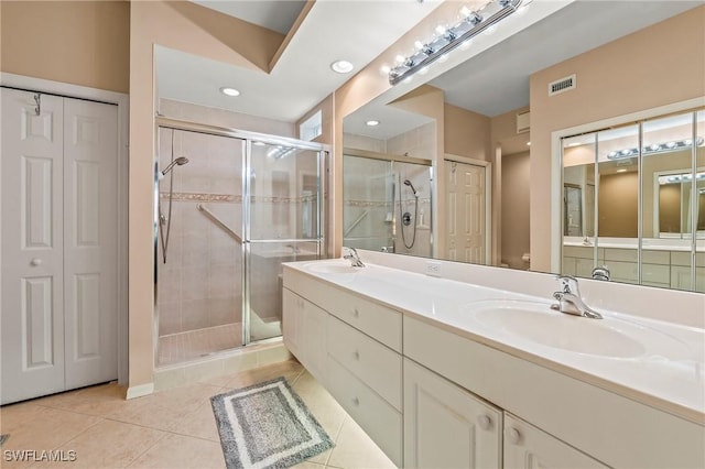 bathroom featuring tile patterned flooring, vanity, and walk in shower