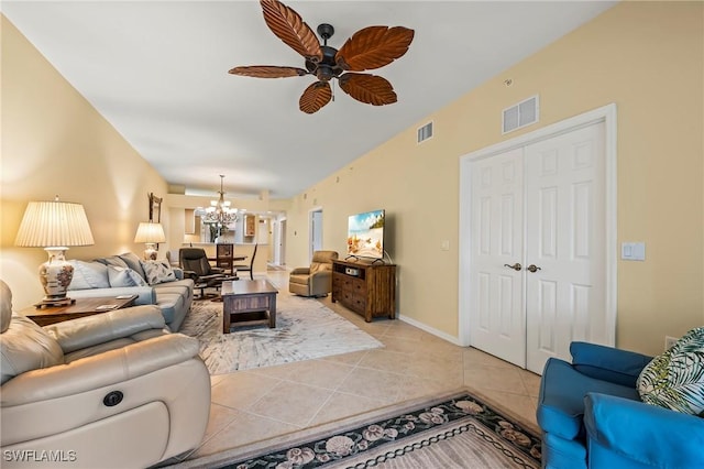 living room with lofted ceiling, light tile patterned floors, and ceiling fan with notable chandelier