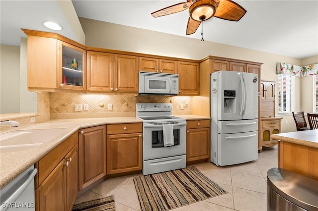 kitchen with sink, decorative backsplash, light tile patterned floors, ceiling fan, and white appliances