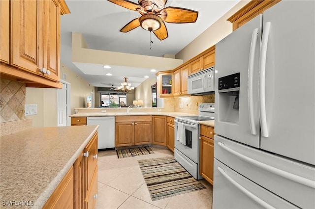 kitchen featuring light tile patterned flooring, decorative backsplash, white appliances, and kitchen peninsula