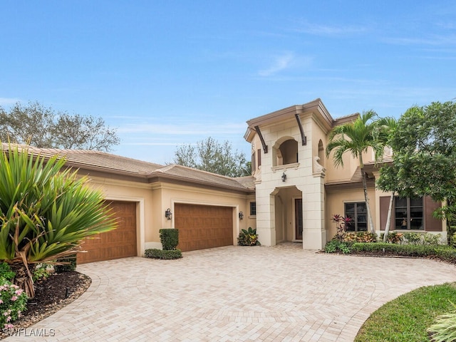 view of front of property with a garage, decorative driveway, and stucco siding