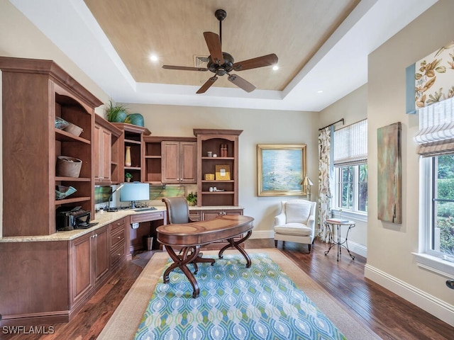 28732 La Caille Dr, Naples, FL 34119 - office space featuring baseboards, built in desk, ceiling fan, a raised ceiling, and dark wood-type flooring