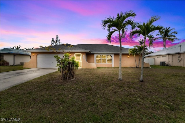 ranch-style house featuring driveway, an attached garage, cooling unit, a yard, and stucco siding