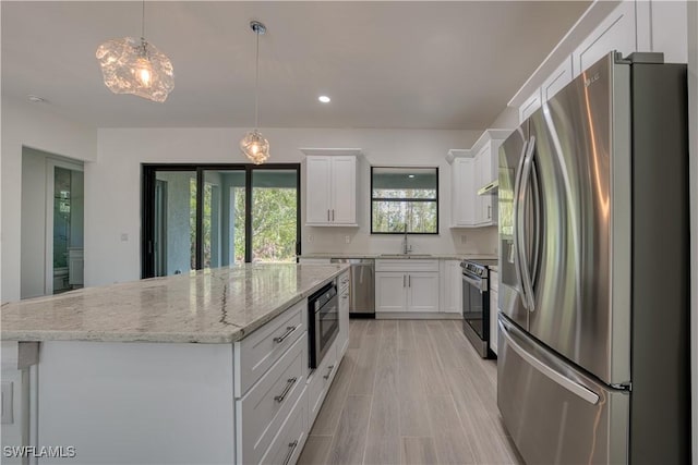 kitchen featuring white cabinetry, appliances with stainless steel finishes, a center island, and sink