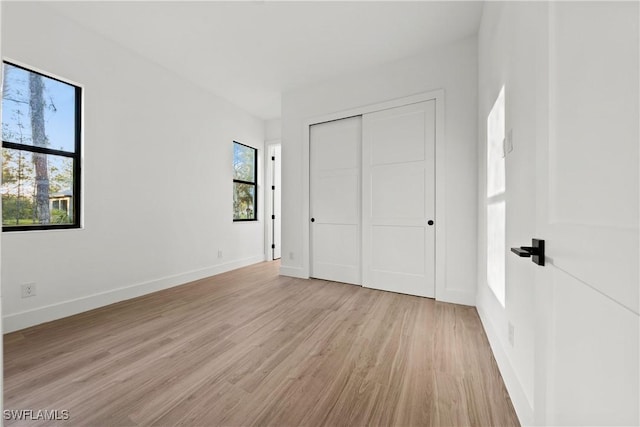 unfurnished bedroom featuring light hardwood / wood-style floors and a closet