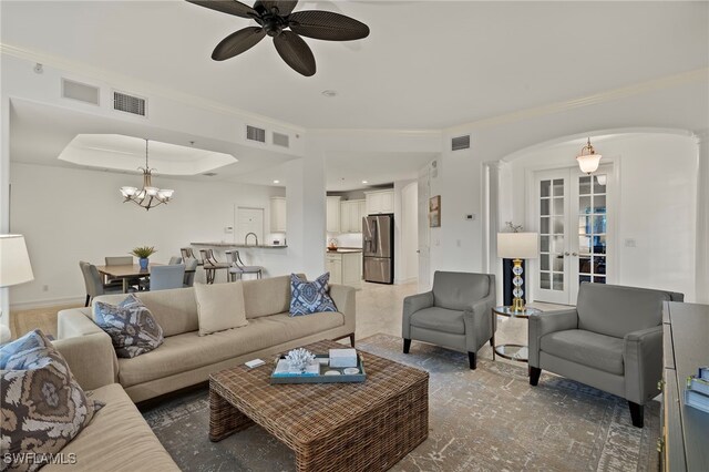 living area featuring arched walkways, a raised ceiling, and visible vents