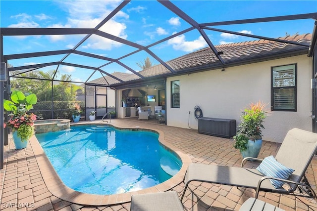 view of pool with glass enclosure, a patio area, and a pool with connected hot tub