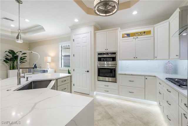 kitchen featuring stainless steel double oven, gas cooktop, a sink, visible vents, and a raised ceiling