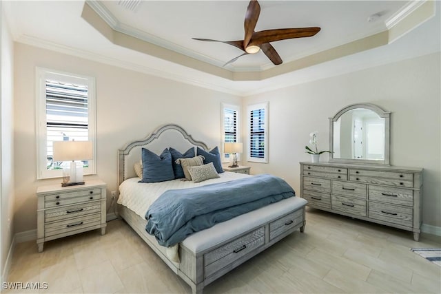 bedroom with ornamental molding, a tray ceiling, and multiple windows