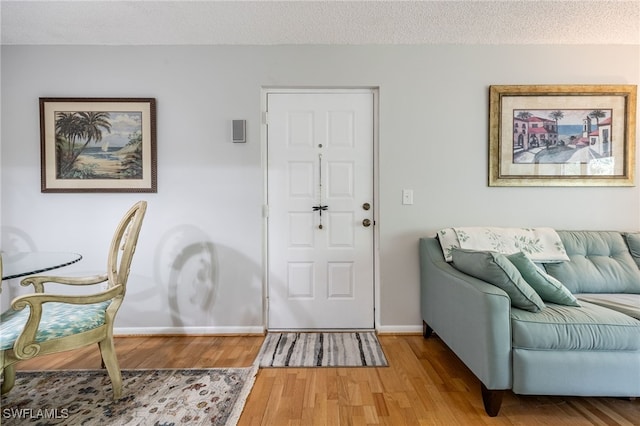 foyer entrance with hardwood / wood-style floors and a textured ceiling