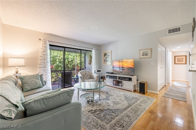 living room featuring a textured ceiling and light wood-type flooring