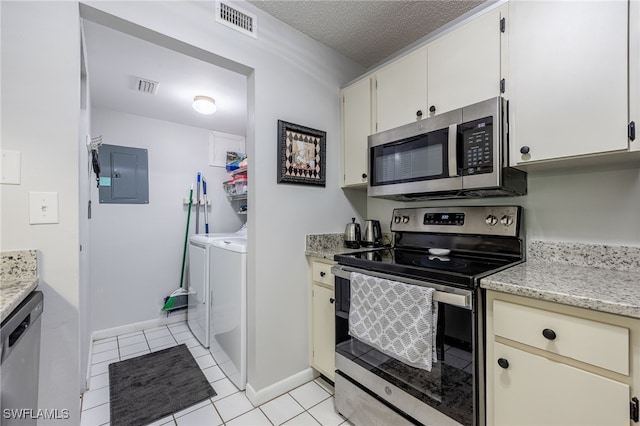 kitchen featuring washer and clothes dryer, stainless steel appliances, electric panel, a textured ceiling, and light tile patterned flooring