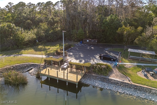 view of dock featuring a lawn and a water view