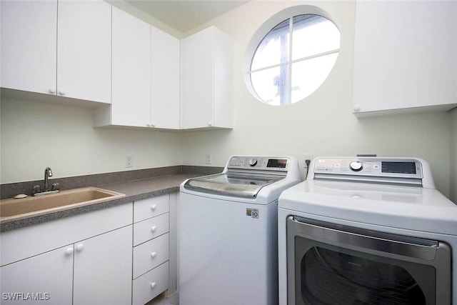 laundry area featuring sink, cabinets, and independent washer and dryer