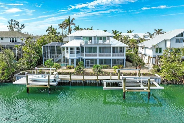 rear view of property with a lanai, a balcony, and a water view