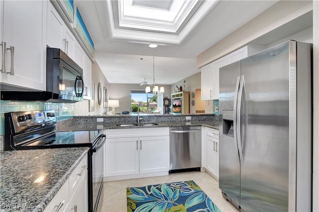 kitchen with light tile patterned flooring, stainless steel appliances, a sink, white cabinetry, and dark stone counters