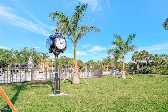 view of community featuring a yard and fence