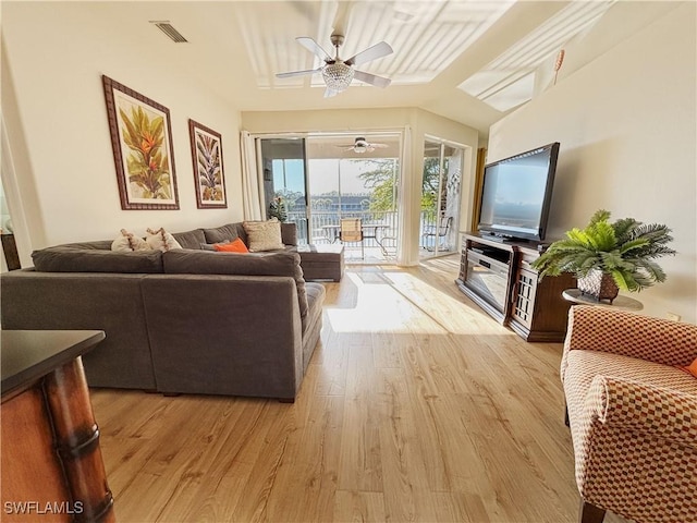 living room featuring ceiling fan, vaulted ceiling, and light hardwood / wood-style floors