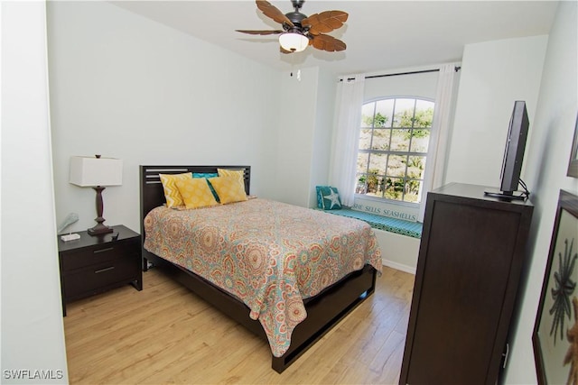 bedroom featuring light wood-style floors, baseboards, and a ceiling fan