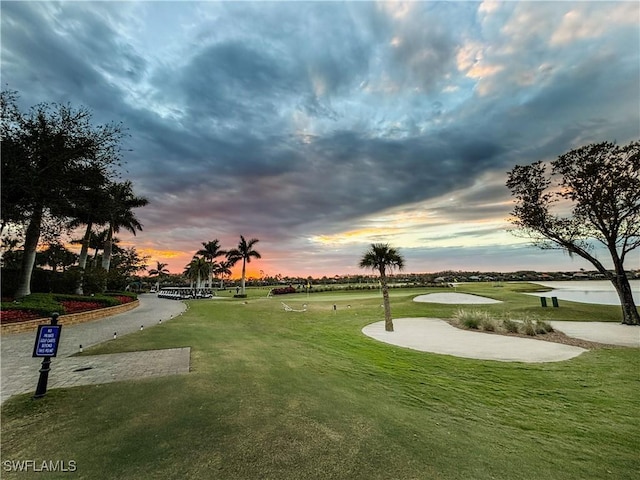 view of property's community featuring a water view, view of golf course, and a yard