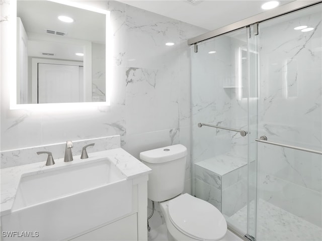 bathroom with tile walls, vanity, toilet, and walk in shower