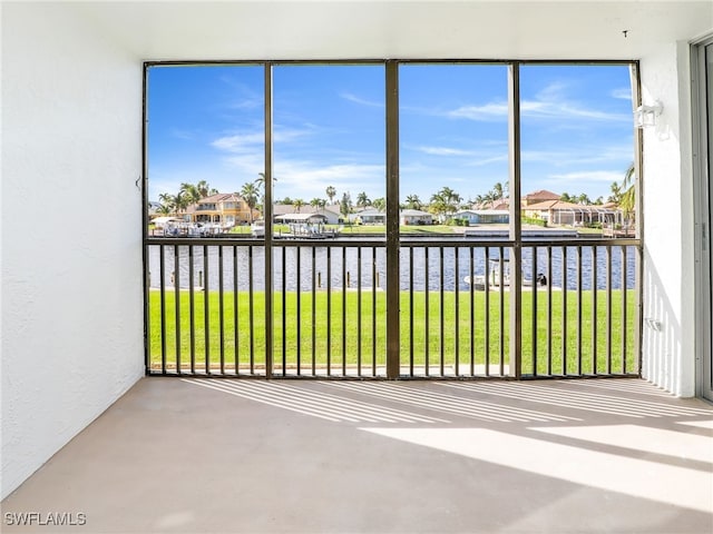 unfurnished sunroom featuring a water view