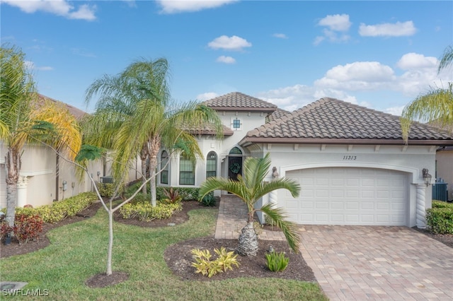 mediterranean / spanish-style house featuring a garage and a front lawn