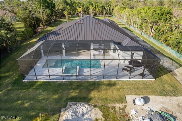 view of pool with a lanai, a patio, and a lawn