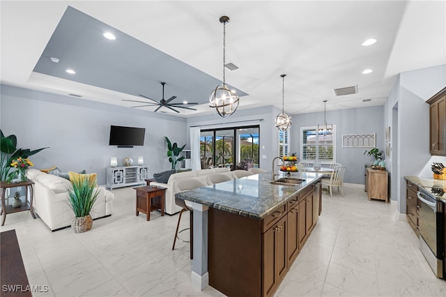 142 SW 35th Ave, Cape Coral, FL 33991 - kitchen featuring sink, pendant lighting, an island with sink, electric stove, and dark stone counters