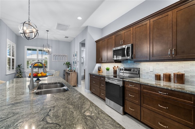 142 SW 35th Ave, Cape Coral, FL 33991 - kitchen featuring appliances with stainless steel finishes, sink, dark stone countertops, a chandelier, and dark brown cabinets