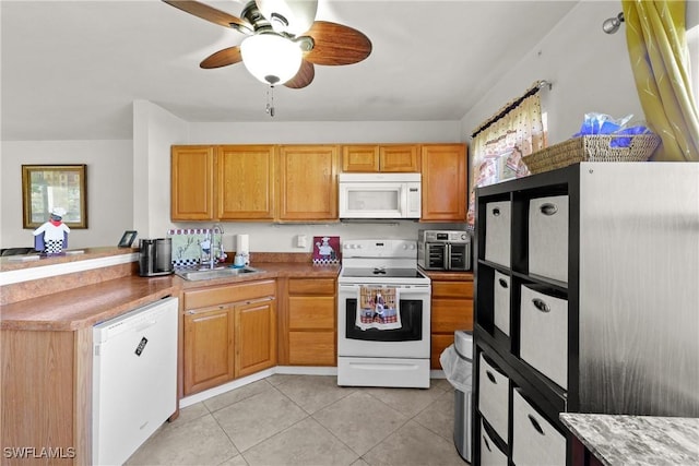 kitchen with sink, white appliances, light tile patterned floors, and ceiling fan