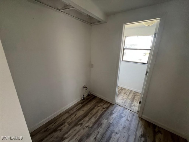 clothes washing area with baseboards and dark wood finished floors