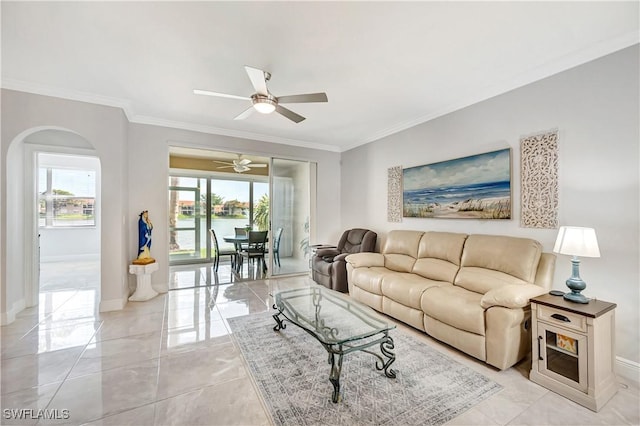 living room featuring plenty of natural light, ornamental molding, ceiling fan, and a water view