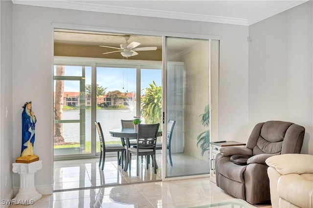 dining area with crown molding, ceiling fan, and a water view