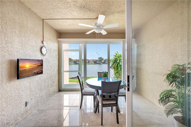 tiled dining room featuring a textured ceiling and ceiling fan