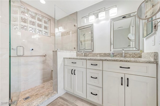 bathroom featuring vanity and a shower with door