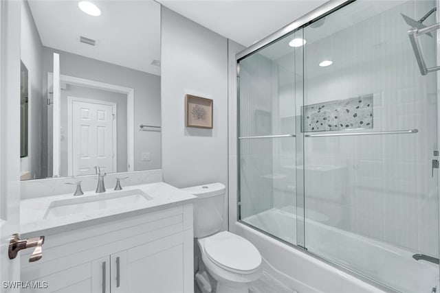 full bathroom with vanity, toilet, and combined bath / shower with glass door