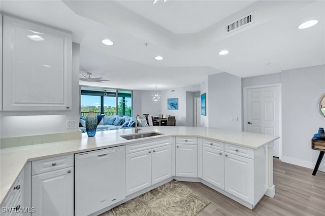 kitchen featuring kitchen peninsula, white cabinetry, sink, light hardwood / wood-style floors, and white dishwasher