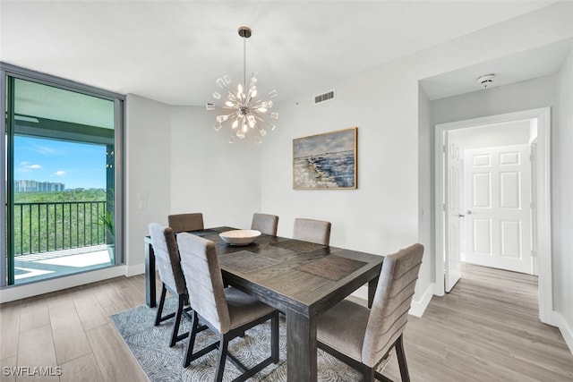 dining room featuring a notable chandelier, light hardwood / wood-style flooring, and floor to ceiling windows