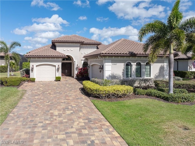 mediterranean / spanish-style house featuring a garage and a front lawn