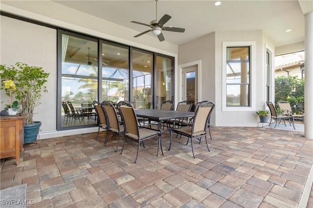 view of patio / terrace featuring ceiling fan and glass enclosure