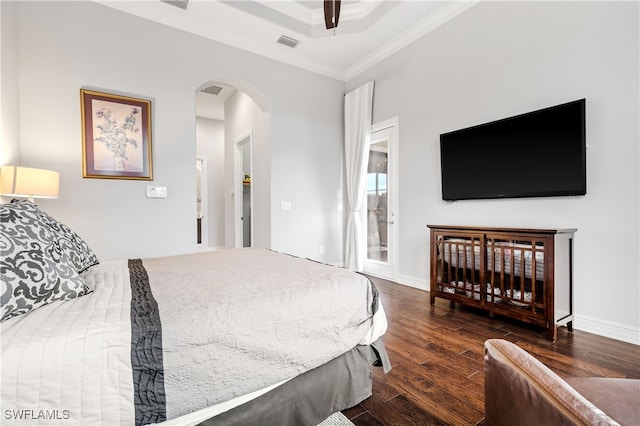 bedroom with dark hardwood / wood-style floors, access to outside, ceiling fan, a tray ceiling, and crown molding