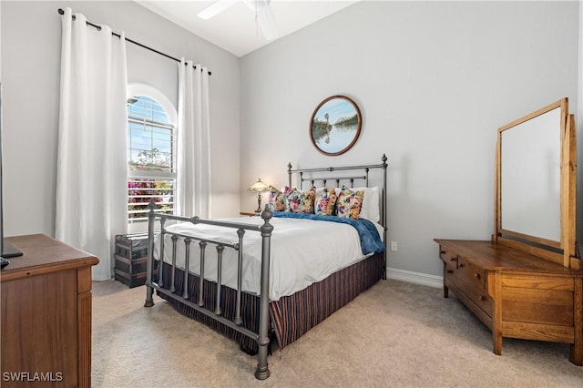 bedroom featuring lofted ceiling and light carpet