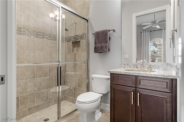 bathroom with ceiling fan, vanity, toilet, and an enclosed shower