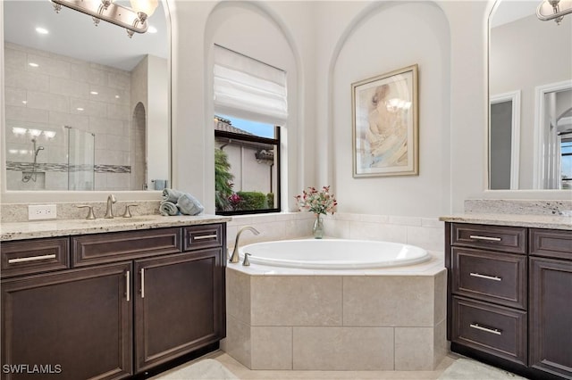 bathroom featuring vanity and independent shower and bath