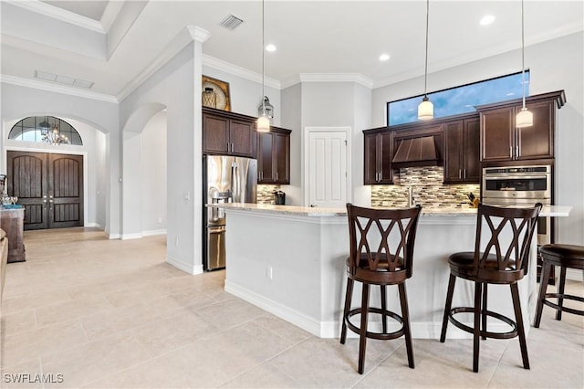 kitchen featuring pendant lighting, light stone counters, custom exhaust hood, and appliances with stainless steel finishes