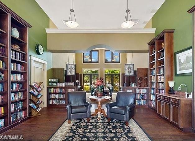 living area featuring ornamental molding, sink, and dark hardwood / wood-style flooring