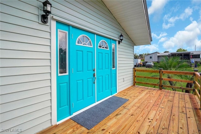 view of exterior entry with a wooden deck