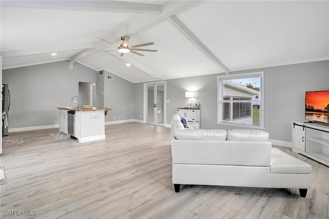 living room featuring lofted ceiling with beams, sink, ceiling fan, and light hardwood / wood-style flooring