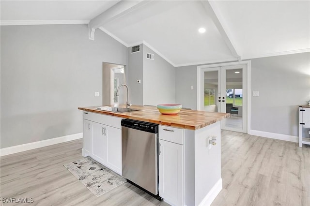 kitchen with butcher block counters, sink, white cabinetry, dishwasher, and a kitchen island with sink